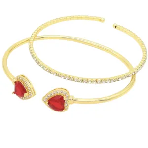 Bracciale rigido aperto dorato con cristallo zircone cuore rosso e dettagli strass.