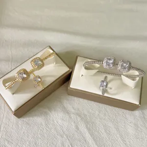 Detailopname van de geometrische zirkonia armband en ring set in goud en zilver.