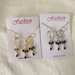 Detailed view of French vintage zirconia tassel necklace and earrings set in gold and silver.