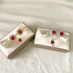 Gedetailleerde opname van rode zirkoon armband und ring set in elegante geschenkdozen.