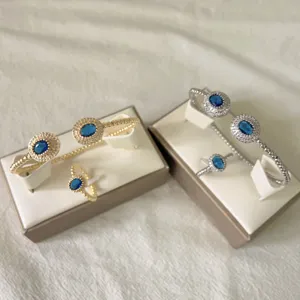 Gold and silver tone open cuff bracelet and ring set featuring sparkling blue oval cubic zirconia.