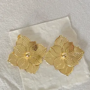 Detailed shot of exquisite 18k gold plated stainless steel floral earrings for luxury banquet wear.