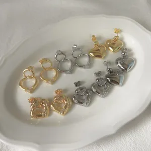 Chic heart stud earrings with sparkling cubic zirconia details in gold and silver.