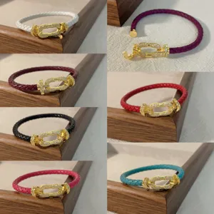 Detail view of multi-color braided leather rope bracelets featuring pavé diamond horseshoe clasps.