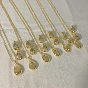 Close-up detail of the gold-plated zircon teardrop pendant necklace and matching earrings set.