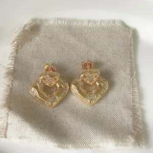 Minimalist gold heart stud earrings with sparkling micro-paved cubic zirconia for trendy wear.