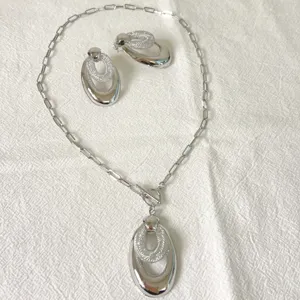 Exquisites Halsketten- und Ohrring-Set aus Edelstahl mit geometrischem Anhänger-Detail.