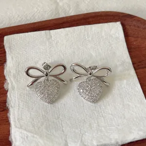 Pendientes colgantes de lazo y corazón de circonita pavé plateados, vista detallada elegante.