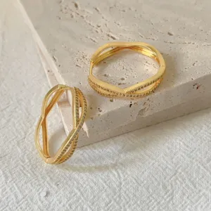 Orecchini incrociati in zirconia cubica dorata dettaglio, elegante gioiello di design geometrico.