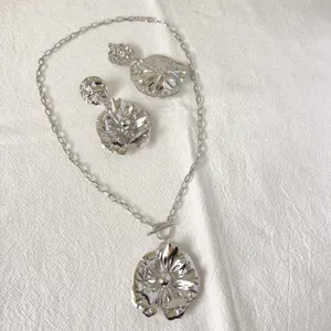 Edelstahl silberfarbenes Blumen Anhänger Halskette Ohrringe Set Detailansicht für elegante Abendmode.