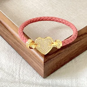 Bracciale in pelle intrecciata rosa con chiusura a cuore in cristallo micropavimentato.