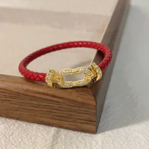 Red braided leather bracelet with gold horseshoe buckle and micro pavé zircon stones for couple.
