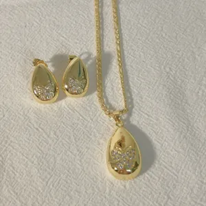 Gold plated teardrop pendant necklace and earrings set featuring micro-inlaid cubic zirconia.