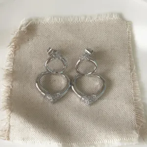 Detailed shot of double heart stud earrings with sparkling micro-set cubic zirconia.