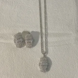 Zilverkleurige sieradenset met ketting met hanger en oorbellen met zirkonia stenen.
