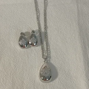 Silver-plated teardrop pendant necklace and earrings set with sparkling micro-inlaid cubic zirconia.