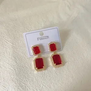 Close-up detail of the vintage red crystal geometric drop earrings with gold-tone pavé rim.
