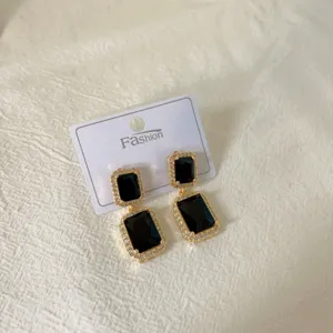 Detailed view of double-layer rectangular black crystal earrings featuring shiny stones.