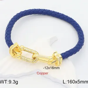 Detailed view of the blue braided leather bracelet with gold pavé U-link clasp and sparkling stones.