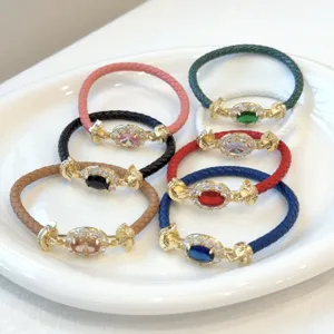 Vista dettagliata di bracciali in pelle intrecciata di lusso con montature in zircone ovale.