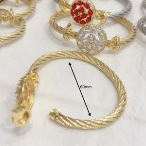 Detailed view of twisted cable bracelet with cubic zirconia centerpiece, golden finish.