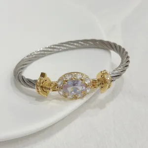 Detail shot of a luxury twisted cable bracelet with a sparkling oval zircon and gold accents.