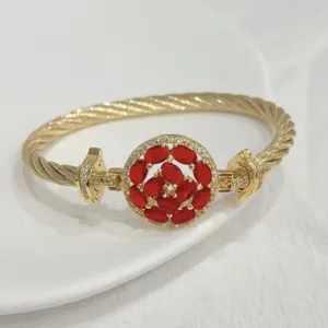 Detailed view of 18k gold plated cable twist bangle bracelet with vibrant red zirconia stone.