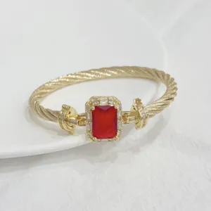 Close-up detail of the vintage gold cable bracelet featuring a striking rectangular red gemstone.