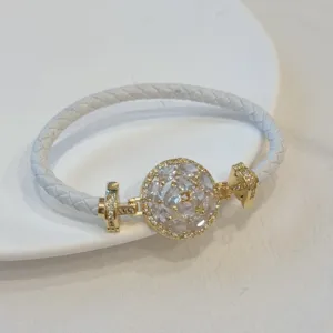 Close-up of white braided leather bracelet with gold-plated micro-set cubic zirconia centerpiece.
