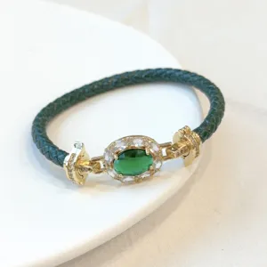 Vista dettagliata del bracciale in pelle intrecciata verde con zircone ovale e rame dorato.
