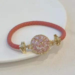 Pink braided leather bracelet with 18k gold plated round pink cubic zirconia clasp detail.