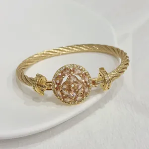 Detail shot of 18k gold plated twisted cable bangle with sparkling zircon center stone.