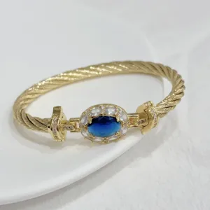 Close-up of 18k gold plated cable bracelet featuring oval blue stone and zirconia accents for women.