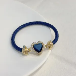 Blue braided leather bracelet with gold-plated heart crystal and sparkling zircon details.
