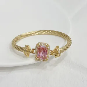Gold plated twisted cable bracelet with a sparkling rectangular pink zircon detail.