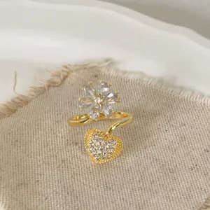 Detail van de bloem- en hartring bezet met glinsterende zirkonen en fijne stralende stenen.