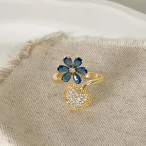 Elegante vergulde koperen ring met blauwe bloem en schitterend zirkonia hart voor dames.
