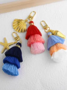 Multilayer tassel keychain detail with shell and starfish metal charms, cute bag accessory.