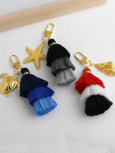 Vue détaillée de porte-clés à pampilles multicouches avec pendentifs marins dorés.