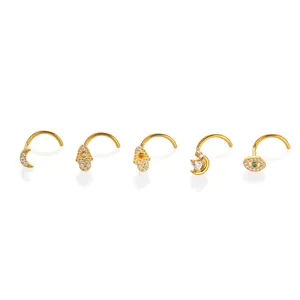 Titanium crystal nose stud set featuring moon, hamsa hand, and evil eye designs for body piercing.