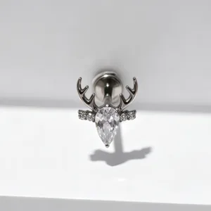 Gedetailleerde close-up van de titanium kraakbeen piercing met een prachtig hertenantennontwerp.
