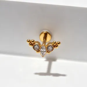 Gouden titanium kraakbeen oorbel detailweergave, fonkelende zirkonia cluster labret piercing.