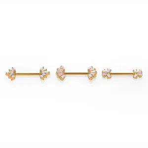 Close-up detail of three gold-tone 316L stainless steel barbell nipple rings with sparkling zirconia.