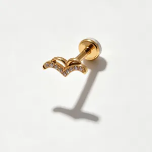Detailopname van een goudkleurige titanium kraakbeen piercing knop met sprankelende zirkonia.
