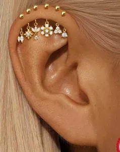 Nahaufnahme Detail von mehrteiligen goldenen Knorpel Helix Ohrringen mit Zirkonia Steinen.