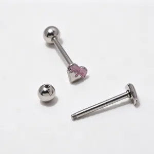 Stainless steel heart barbell detail showing piercing jewelry components and pink enamel design.
