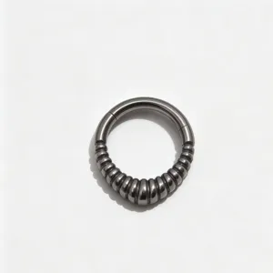 Titanium segment clicker ring detail, ribbed texture septum piercing jewelry, dark metal finish.