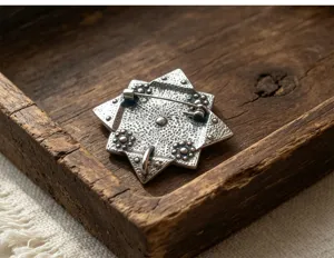 Vue detaillee du mecanisme d'epingle de la broche etoile vintage avec texture unique.