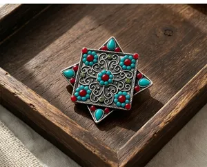 Vue détaillée de la broche étoile octogonale ethnique vintage avec turquoise et style tibétain.