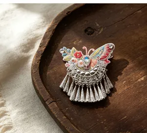 Detailed view of Chinese ethnic embroidered butterfly tassel hair clip with silver-style charms.